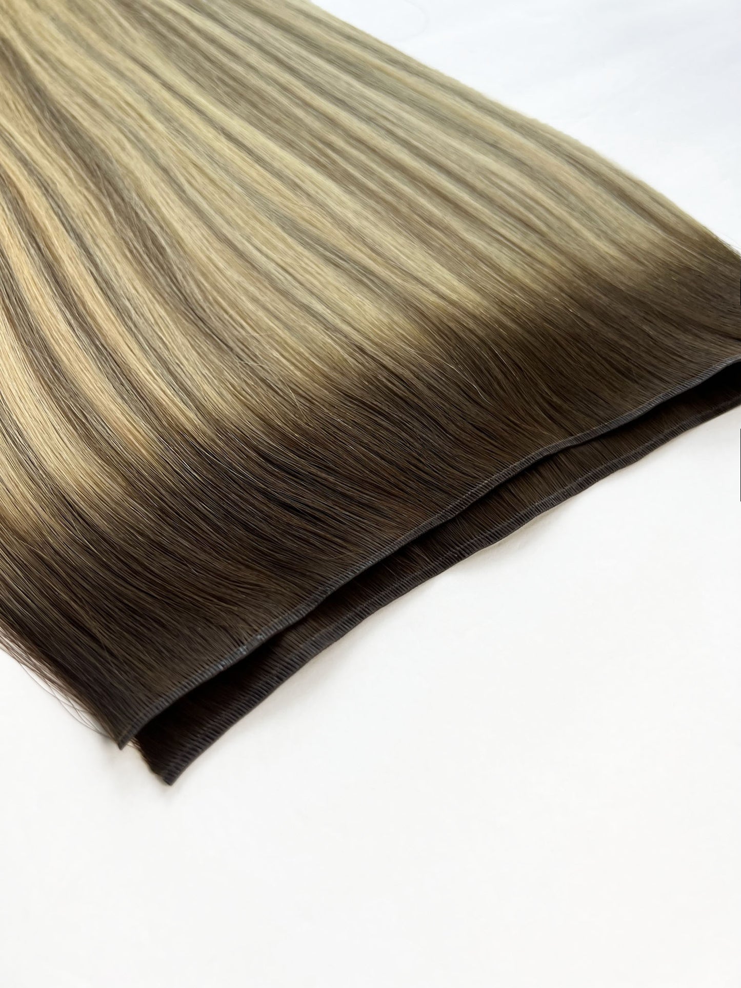 KOVI Volume Genius Weft extensions in a dimensional blonde with a root. 